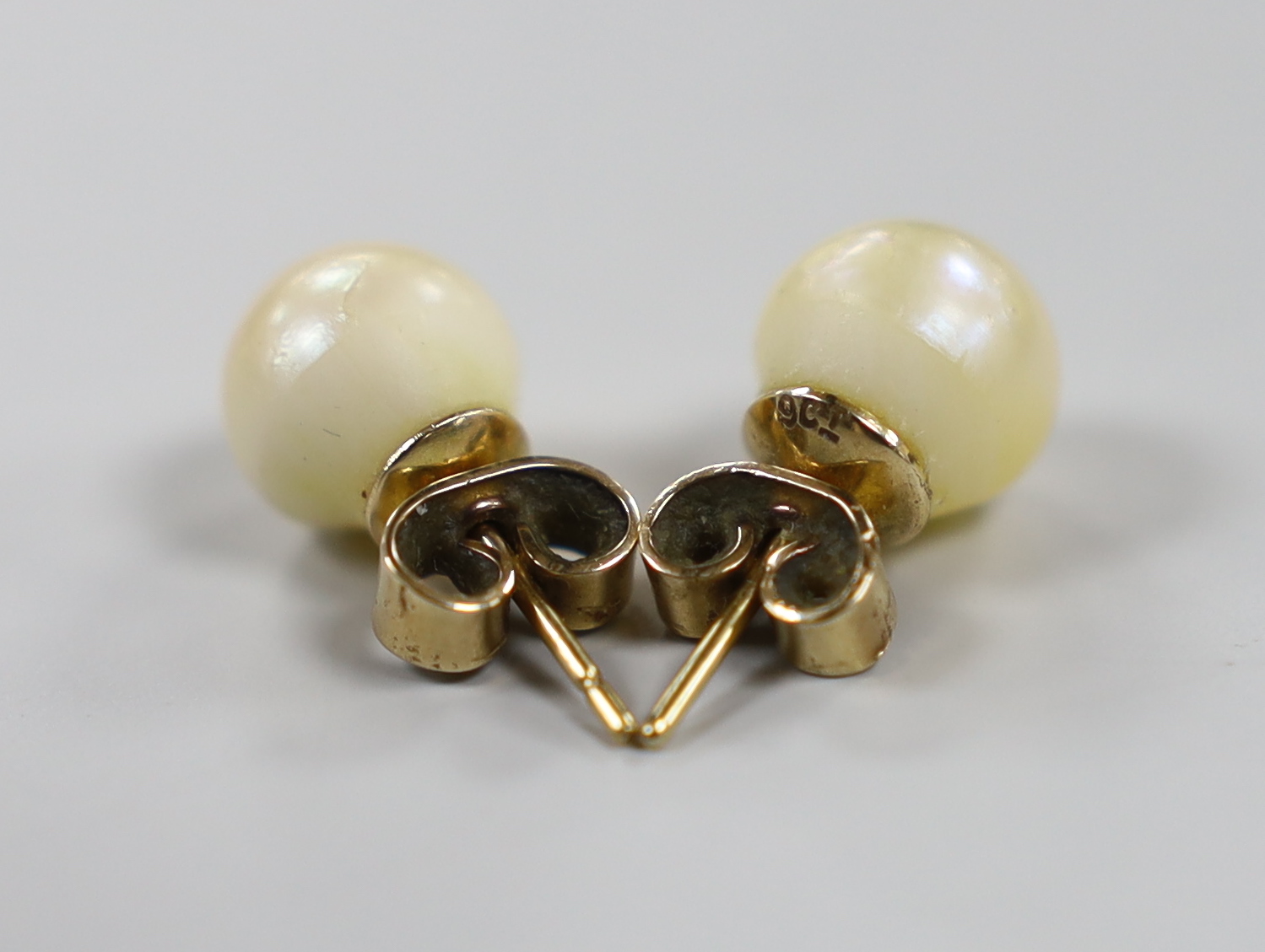 A pair of yellow metal and cultured pearl set ear studs, pearl diameter 9.2mm.